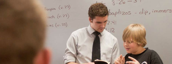 photo of a student mentoring a child