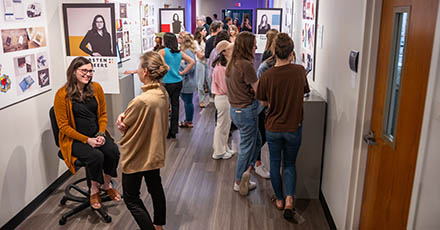 Students and guests attend the graphic design senior capstone show opening in the Sargent Art Building Exhibition Hall at Bob Jones University, March 2, 2024. (Madeline Peters)
